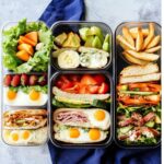 A variety of colorful and nutritious lunchbox meals, perfect for teens, featuring sandwiches, eggs, fresh fruits, salads, and crispy fries, all neatly packed in glass containers.