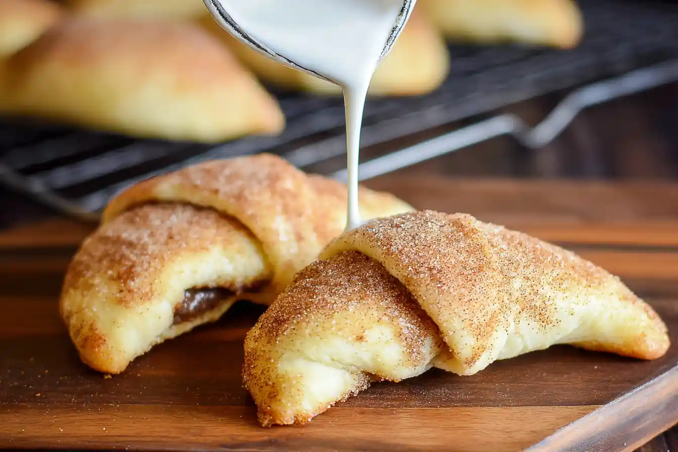 A close-up shows uncooked Cinnamon-Sugar Crescent Dough twists sprinkled with sugar, arranged on parchment paper on a baking sheet, ready to bake.