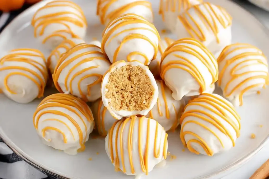 A close-up shot of several delicious No Bake Pumpkin Cheesecake Balls, some rolled in crushed graham crackers and others plain, arranged on a serving plate.