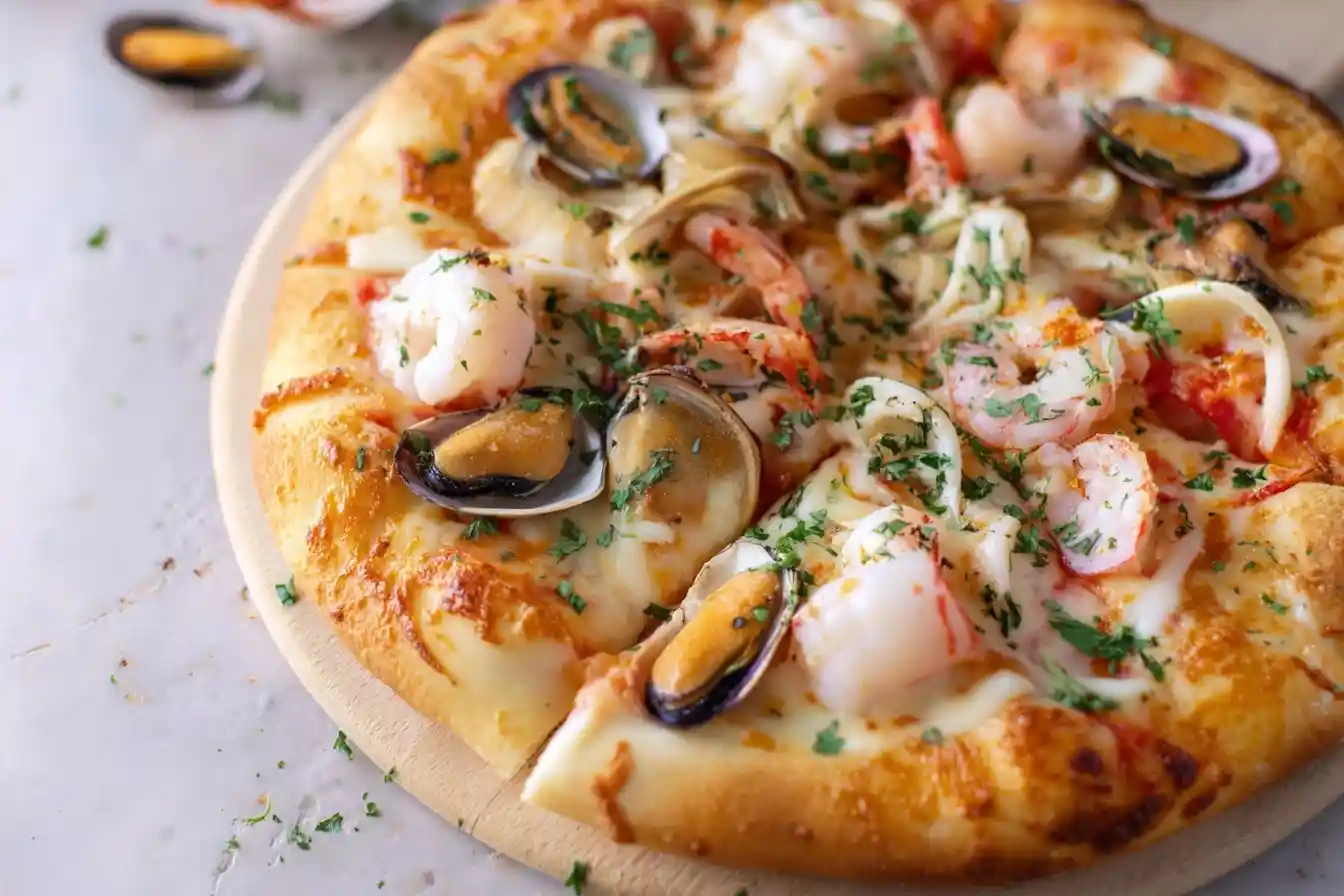 A close-up of a gourmet seafood pizza topped with mussels, shrimp, and fresh parsley on a wooden board.