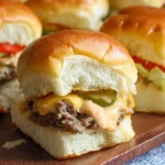 A close-up of homemade cheeseburger sliders on a tray, with one open showing the beef patty, melted cheese, and sauce.