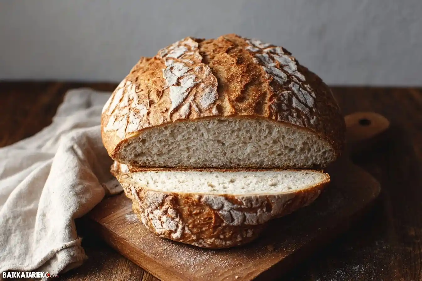 Sliced homemade sourdough bread on a wooden board displaying a golden crust and airy crumb texture.