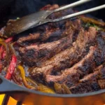 Cooking {{ $('Fetch Recipe Data').first().json["Main Keyword"] }} in a cast iron pot over an open fire.