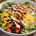 Fresh {{ $('Fetch Recipe Data').first().json["Main Keyword"] }} in a bowl with corn and black beans.