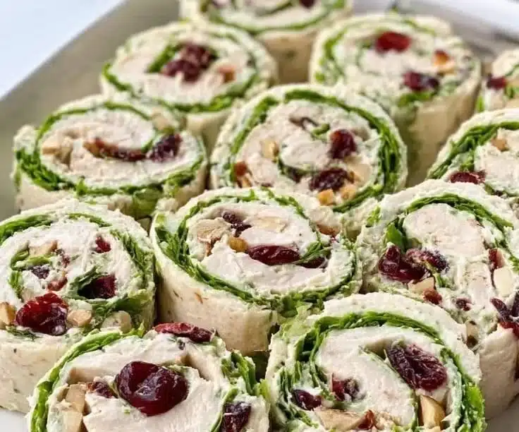 Chicken Cranberry Salad Pinwheels served on a platter with fresh ingredients