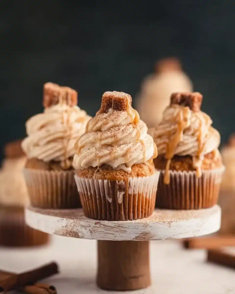 Churro cupcakes with cinnamon cream cheese frosting on a dessert plate.