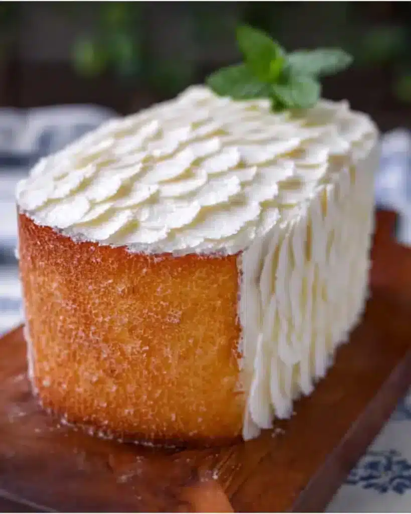 Moist vanilla cake with smooth frosting and decorative sprinkles.