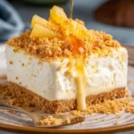 A delicious square slice of pineapple dessert with graham cracker crust and golden syrup drizzle.