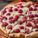 Delicious Raspberry Cheesecake Pizza topped with fresh raspberries and cream cheese