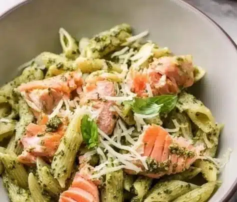 Creamy Salmon Pesto Pasta garnished with fresh herbs and vegetables