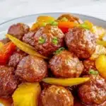 Slow cooker meatball pineapple smokies served in a bowl for a tasty appetizer.