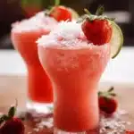 Refreshing Strawberry Coconut Cooler drink served in a glass with strawberries and coconut.