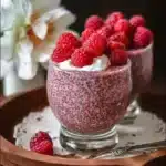 Bowl of Vegan Raspberry Chia Pudding topped with fresh raspberries and mint